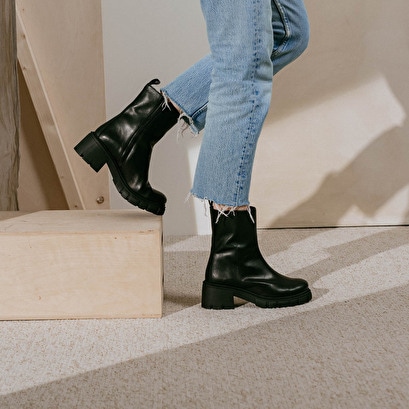 Heeled boots with notched soles in black leather