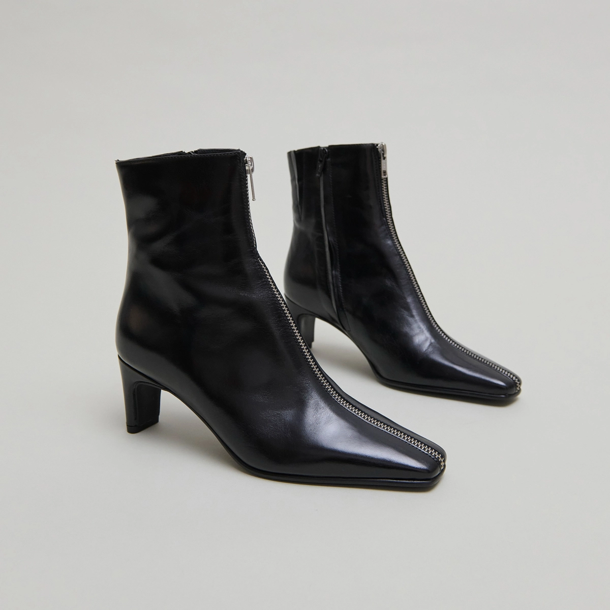 Heeled ankle boots with front zippers in black leather | DANZA