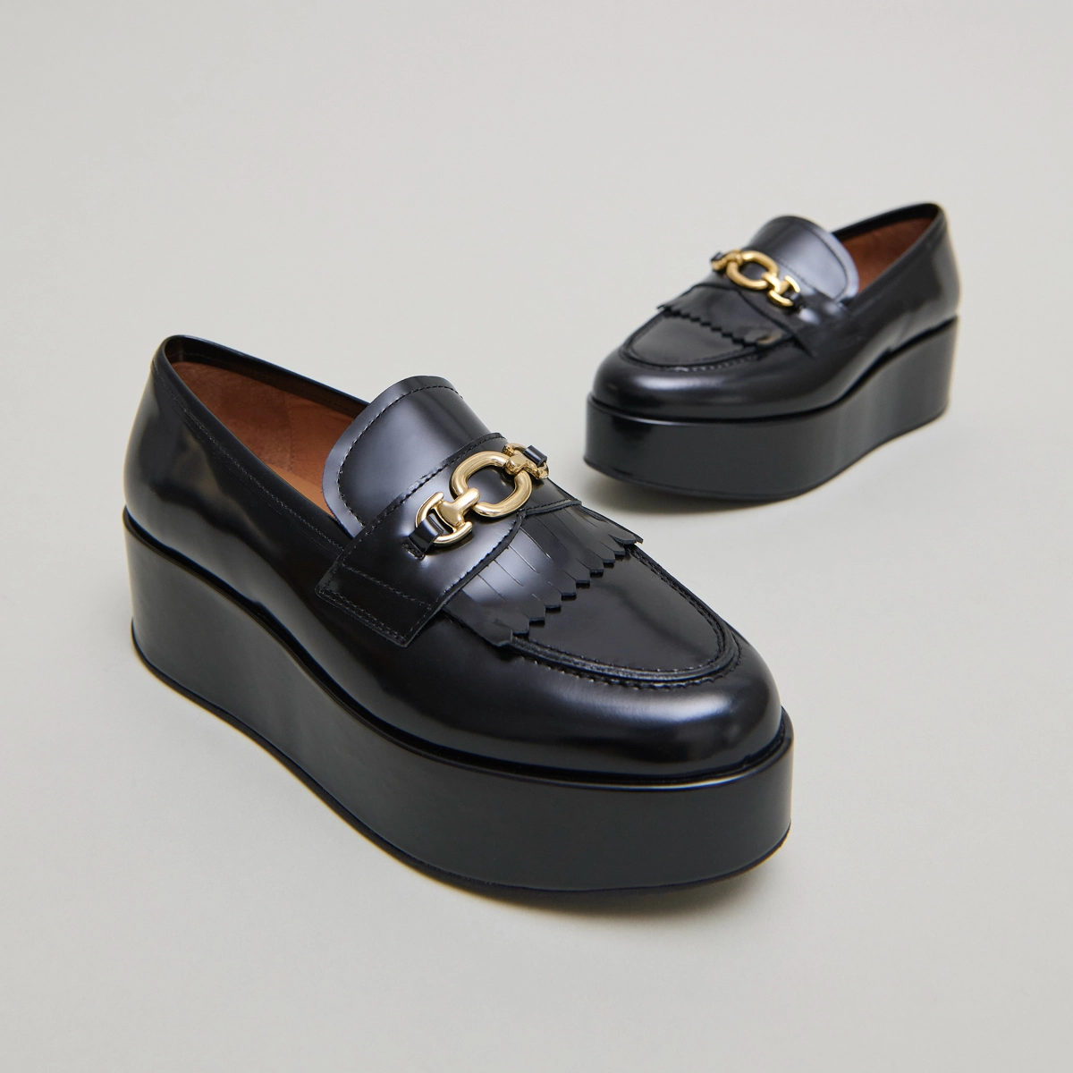 Gold buckle loafers in black glazed leather | DELPHES