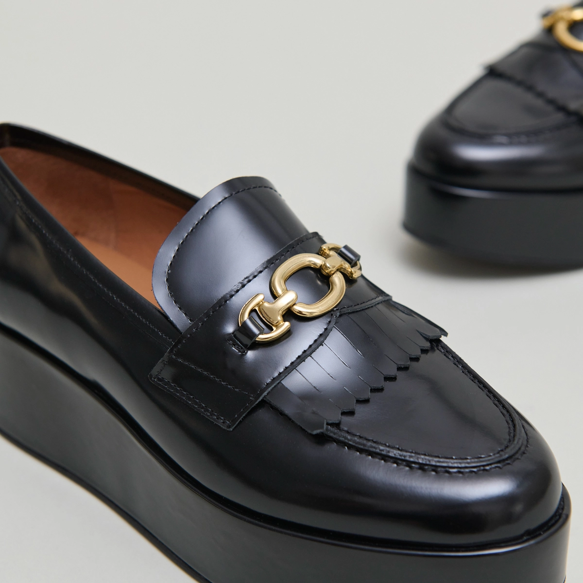 Gold buckle loafers in black glazed leather | DELPHES