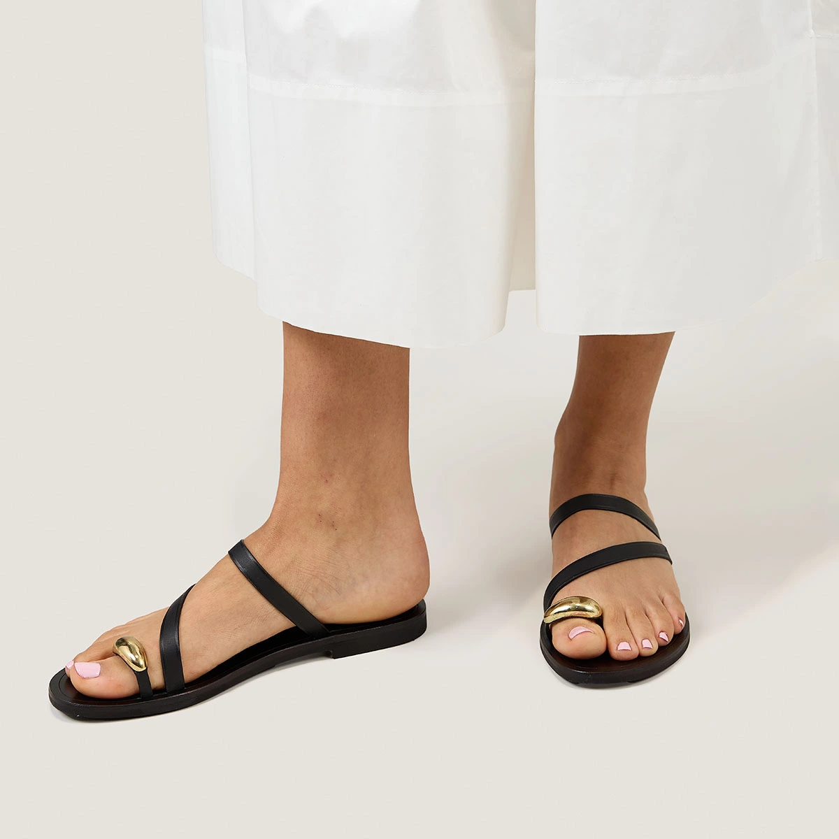 Sandals with slender straps and gold details in black leather | WIFE