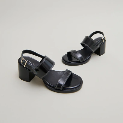Heeled sandals in black glazed leather | blondine