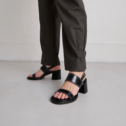 Heeled sandals in black glazed leather | blondine