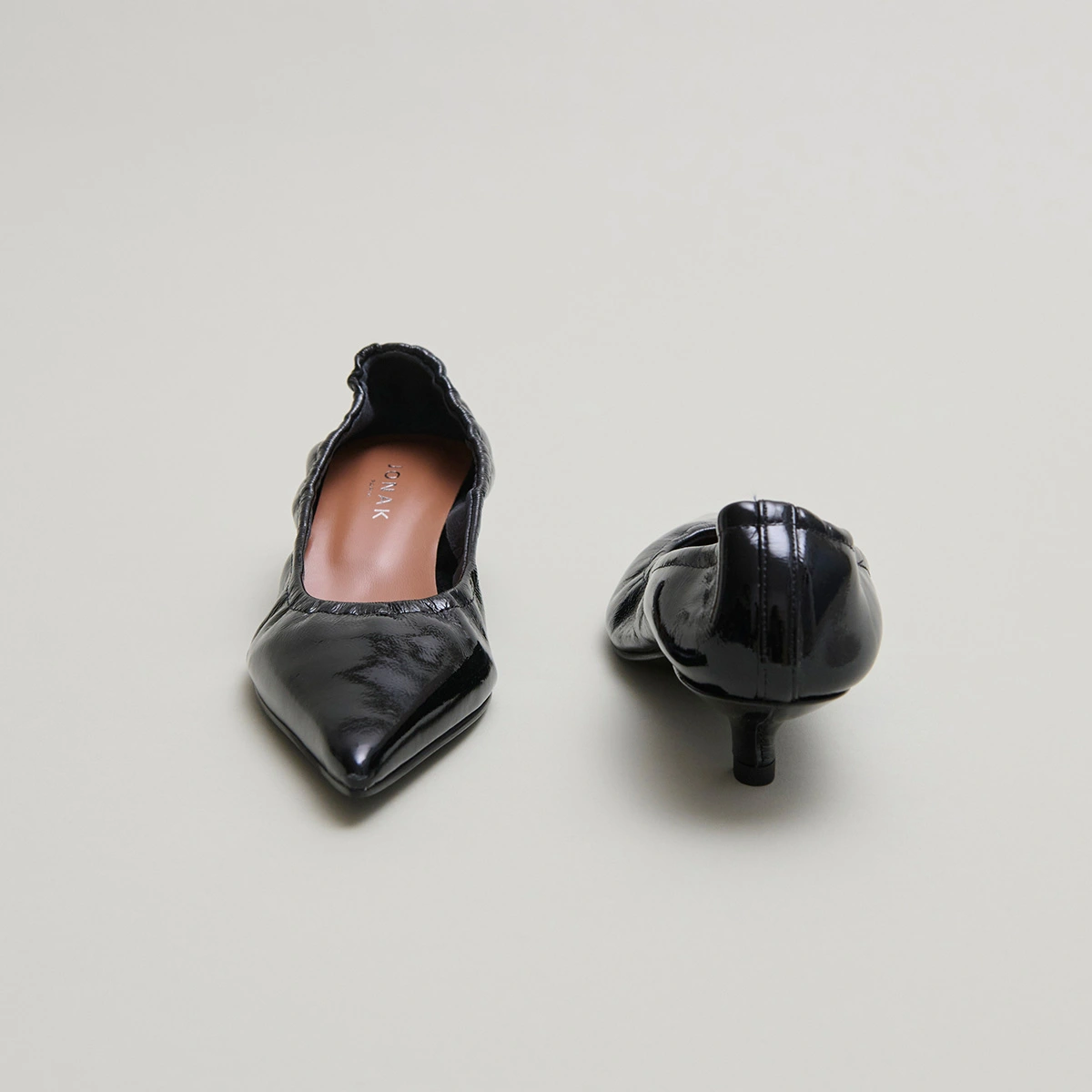 Pointed-toe pumps in black pleated varnish | DOUA