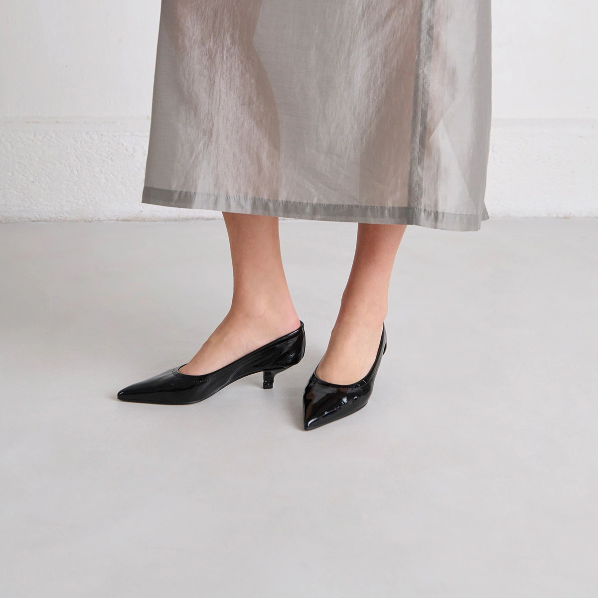 Pointed-toe pumps in black pleated varnish | DOUA