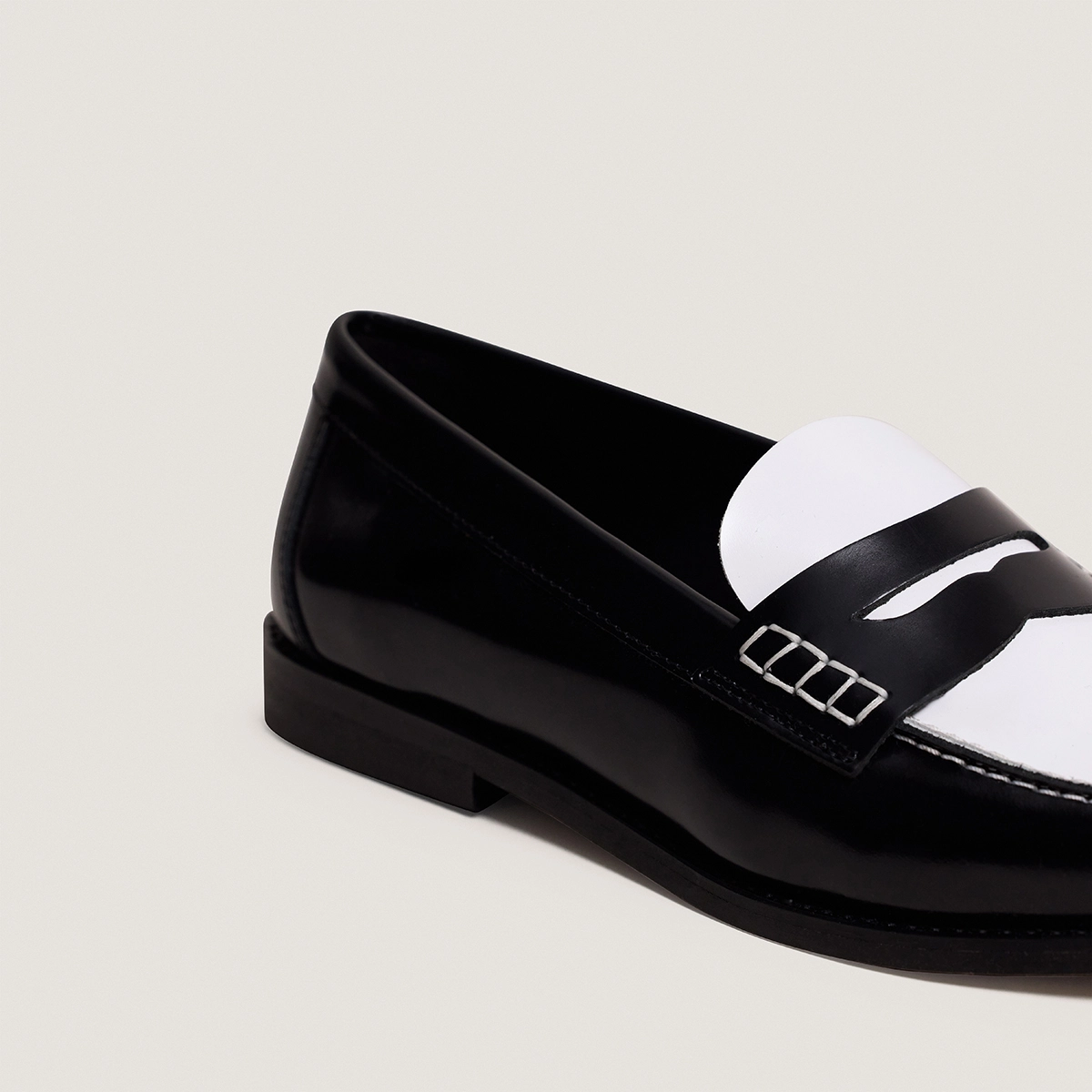 Penny loafers with a pinched platform in black and white patent leather | AUDELYA