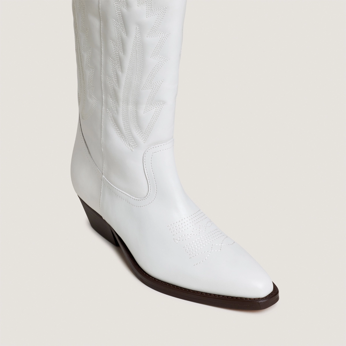 Pointed-toe boots with visible stitching in white aged leather | DELEA