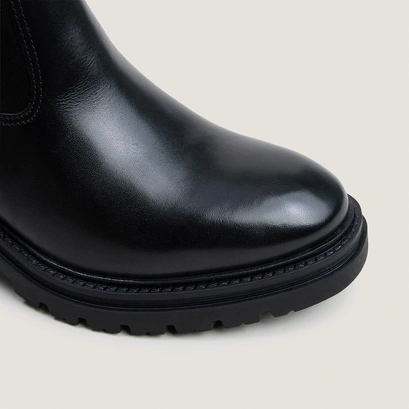 Heeled boots with lug soles in black leather | attitude