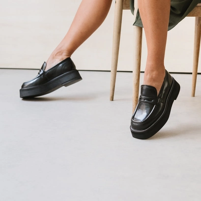 Platform loafers in black glazed leather | daffy