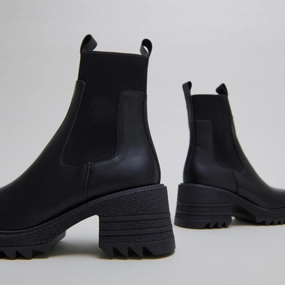 Boots with elastics and notched sole in glazed black leather | dove