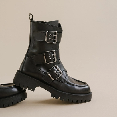 Boots with notched soles and straps in black leather | runner