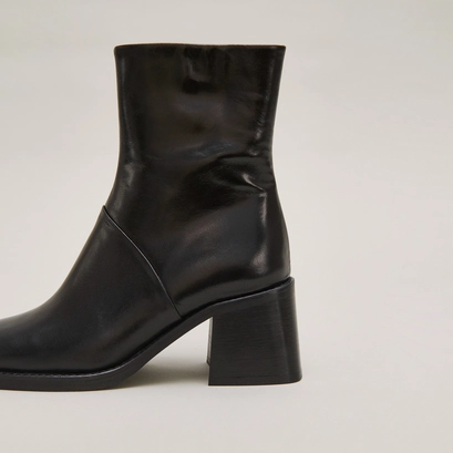 Square-toe boots with exposed seams in black leather | diouma