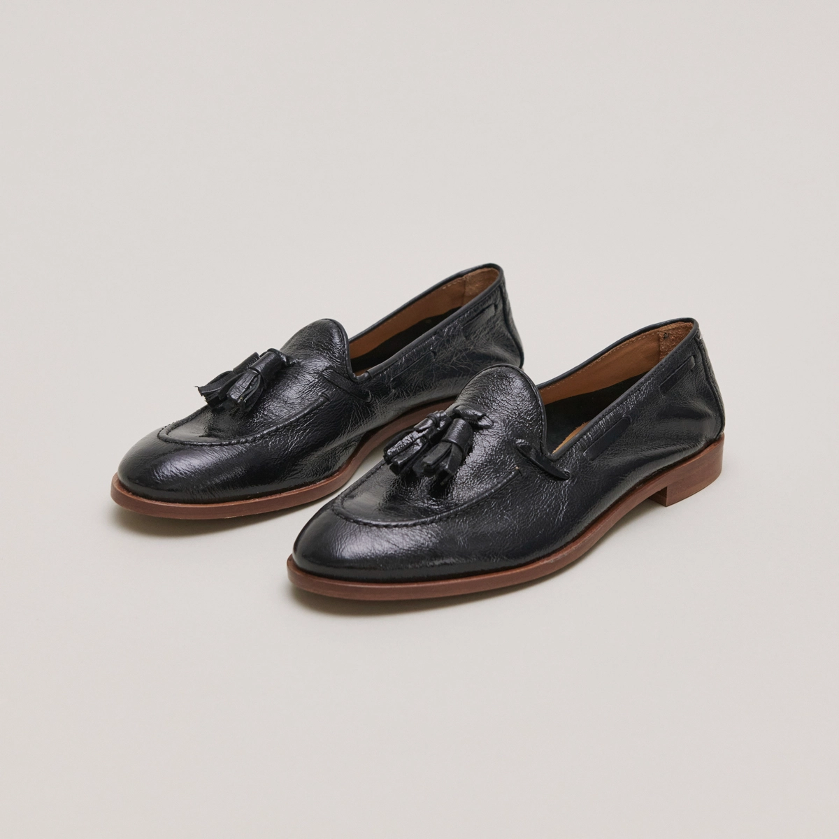 Round toe loafers with pompons in black pleated patent | TIPHAINE