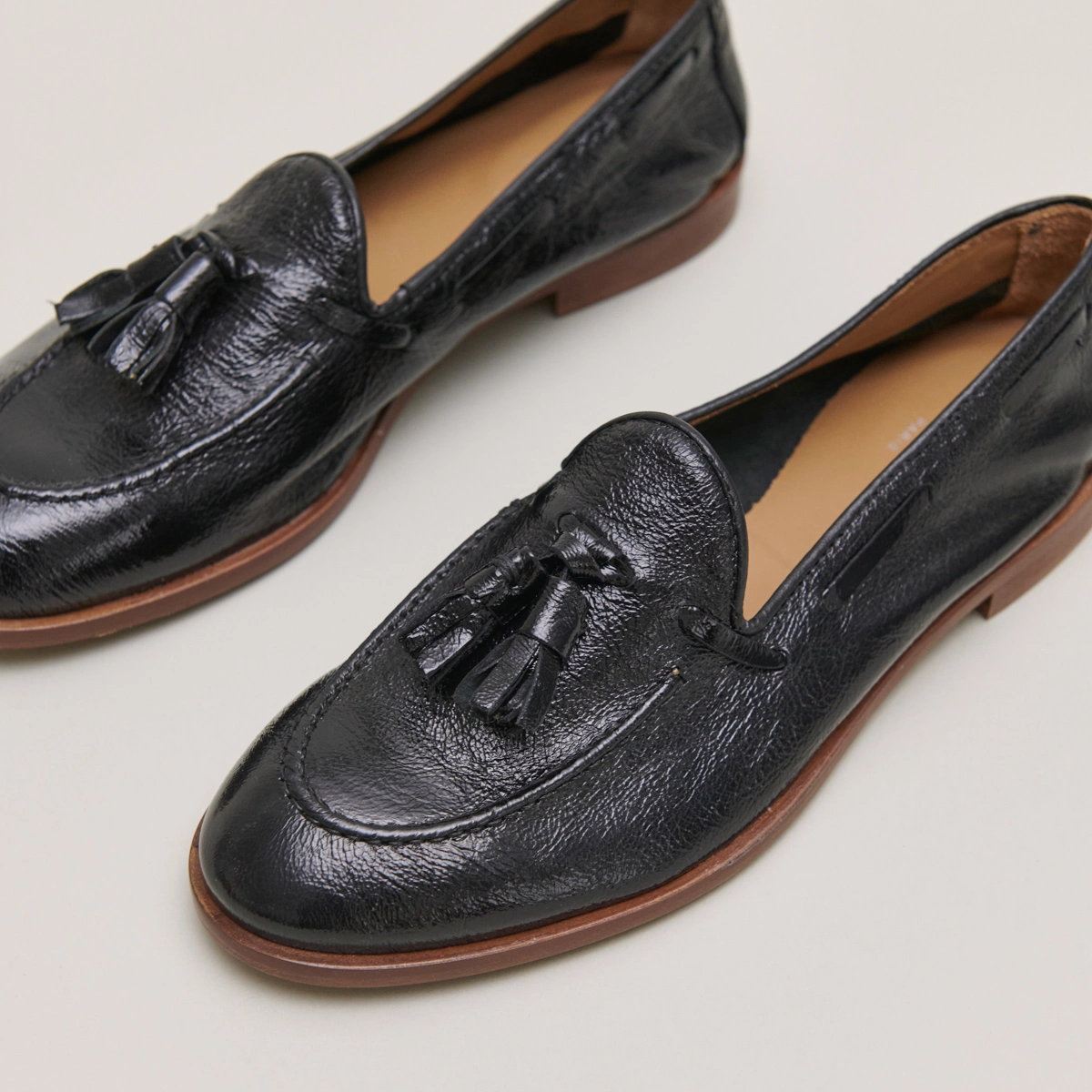 Round toe loafers with pompons in black pleated patent | TIPHAINE