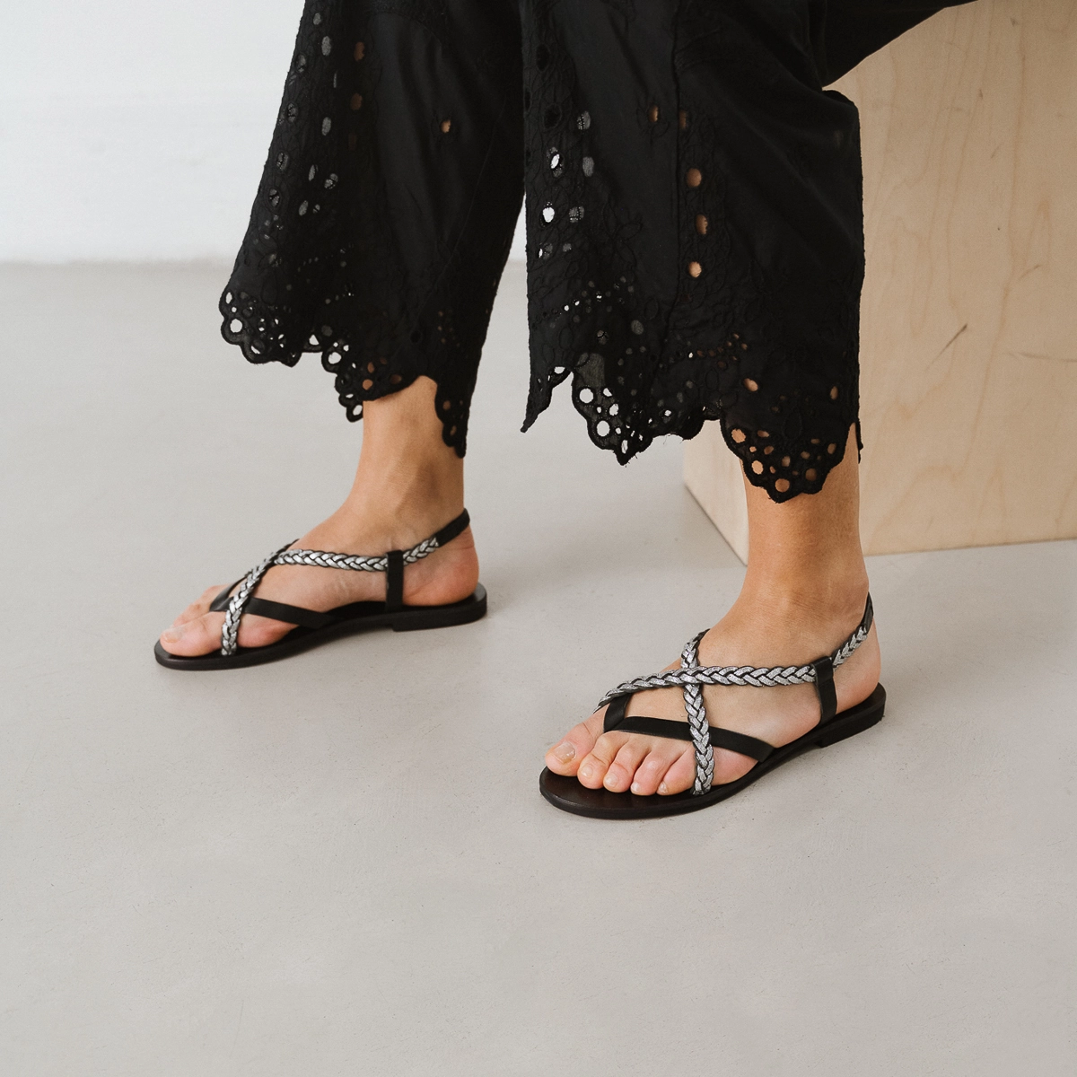 Sandals with braided straps in black and silver leather | WARREN