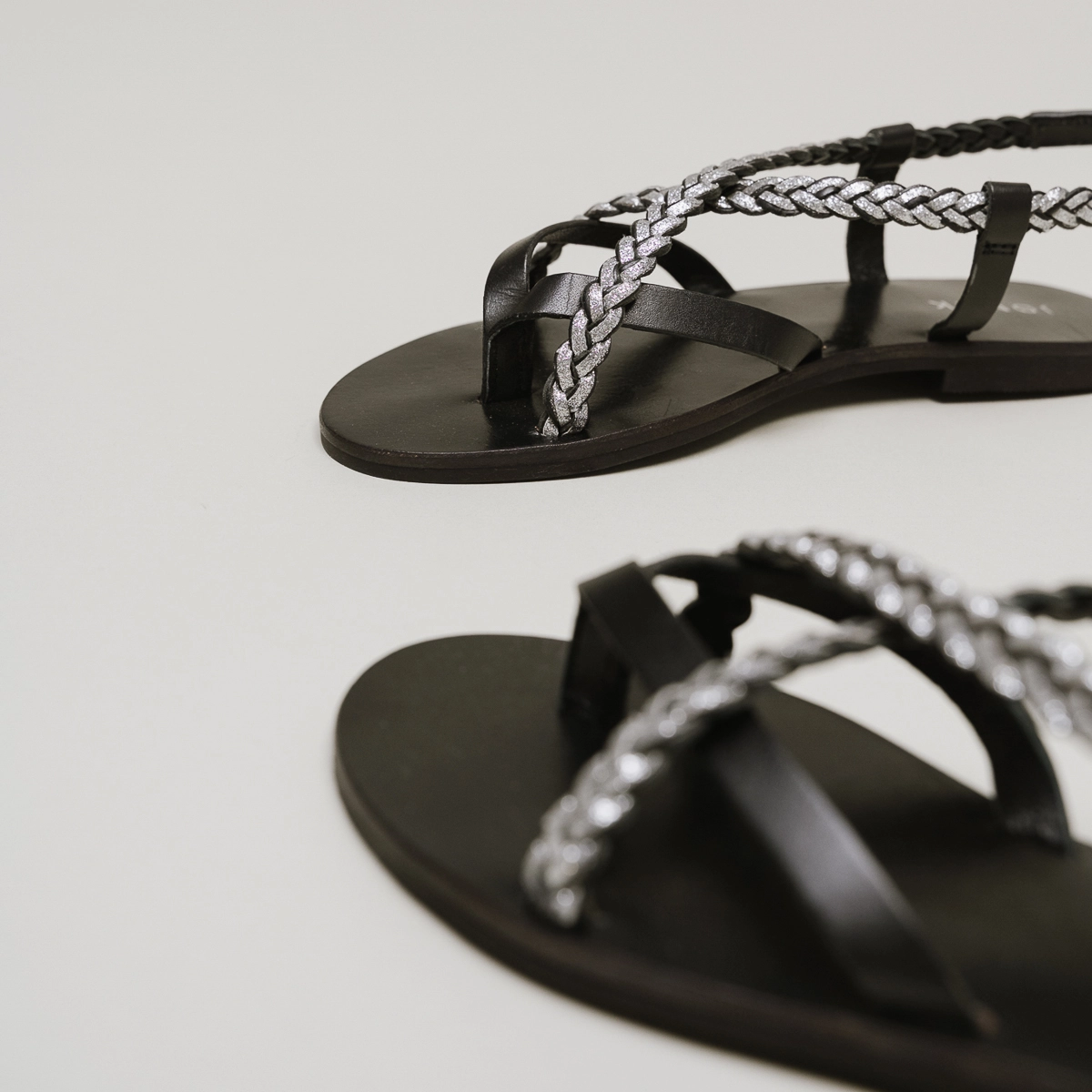 Sandals with braided straps in black and silver leather | WARREN