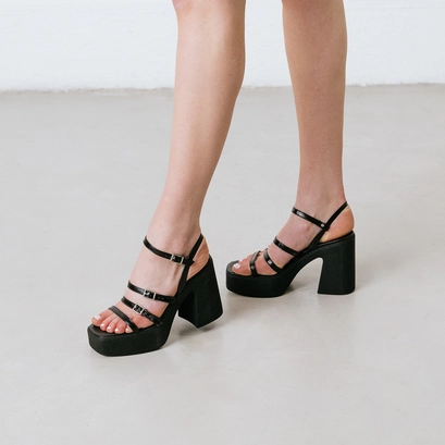 Sandals with straps and platforms in black pleated patent | puzzle