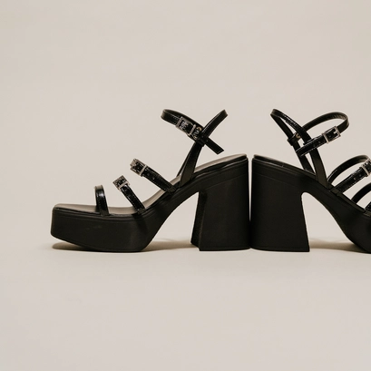 Sandals with straps and platforms in black pleated patent | puzzle