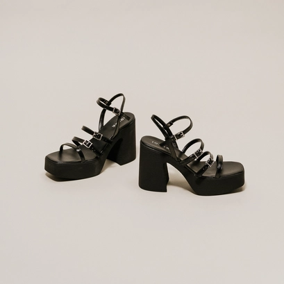 Sandals with straps and platforms in black pleated patent | puzzle