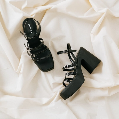 Sandals with straps and platforms in black pleated patent | puzzle