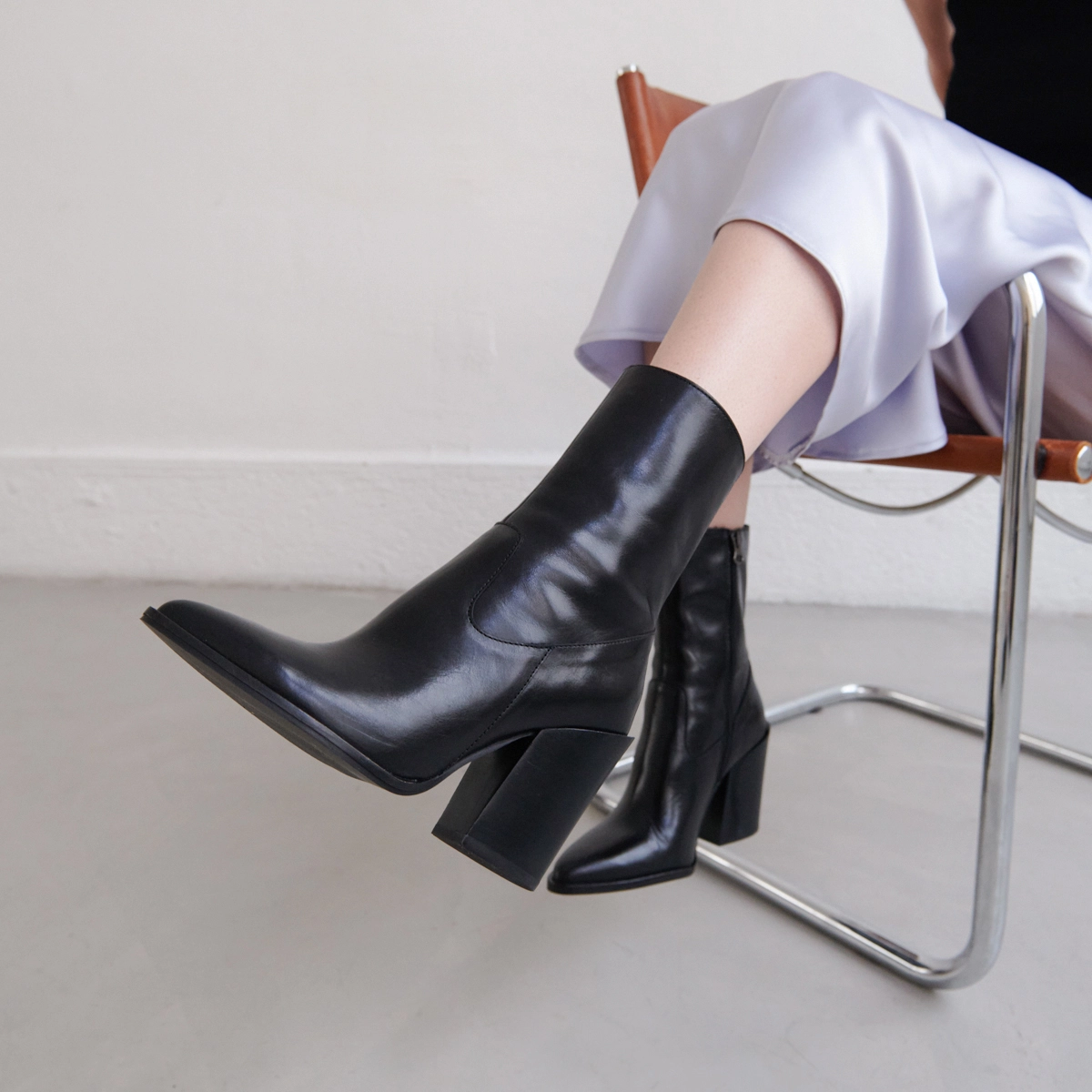 Heeled boots with pointed toes in black leather | BUSTER