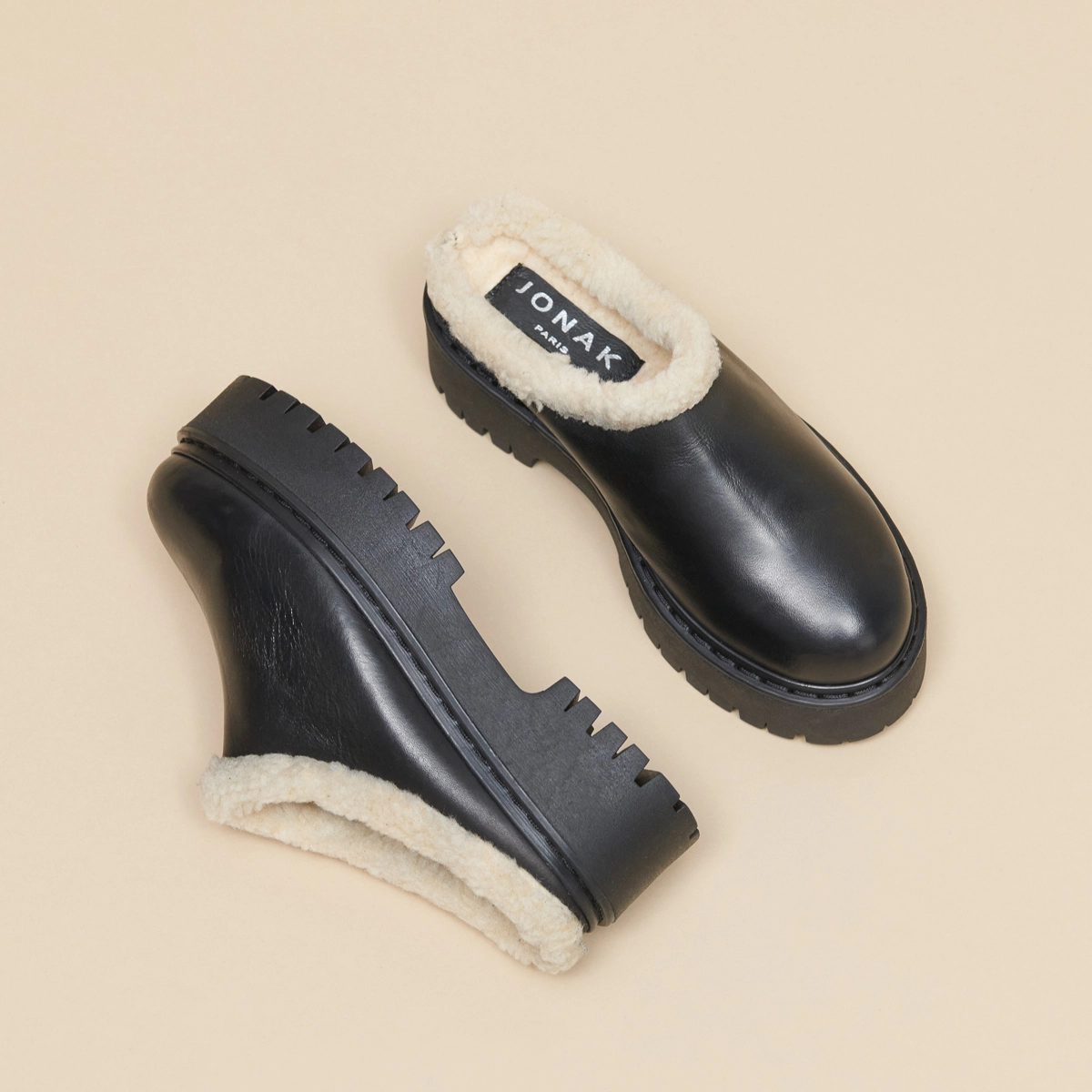 Round-toed mules with notched soles in black leather | RAYA