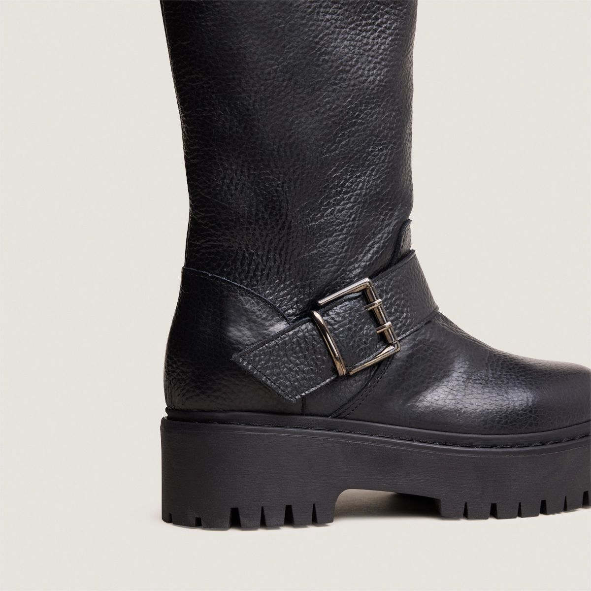 Boots with straps and notched soles in black grained leather | REINE
