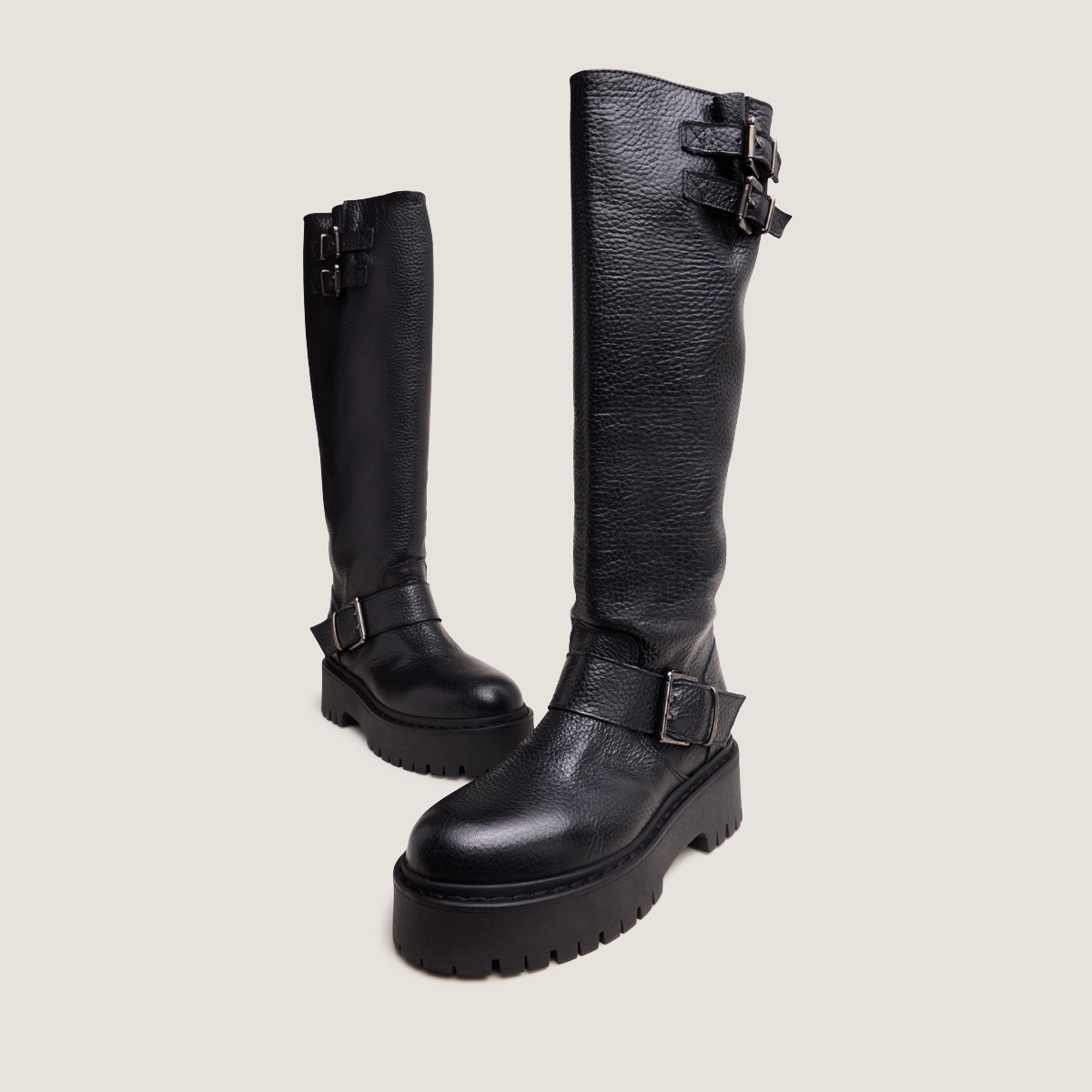 Boots with straps and notched soles in black grained leather | REINE