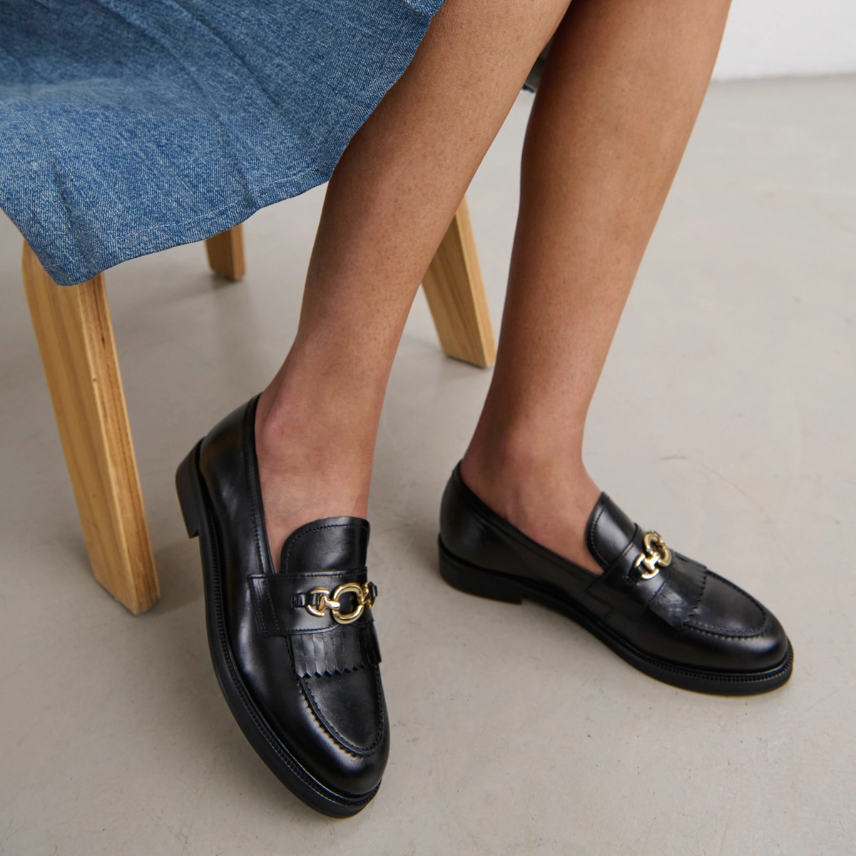 Loafers with gold buckles in black leather | DELPHES