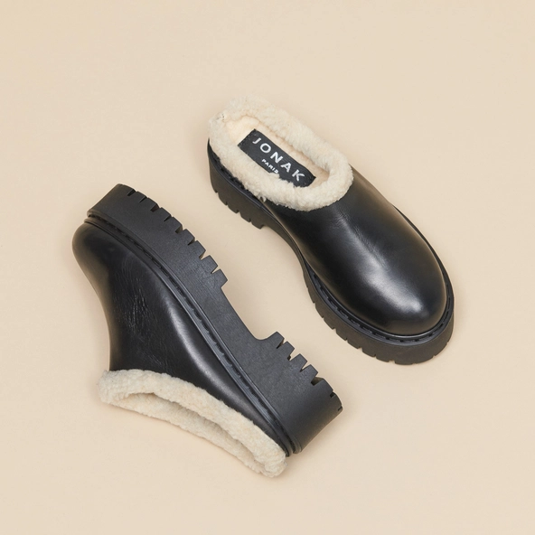 Round-toed mules with notched soles in black leather | RAYA