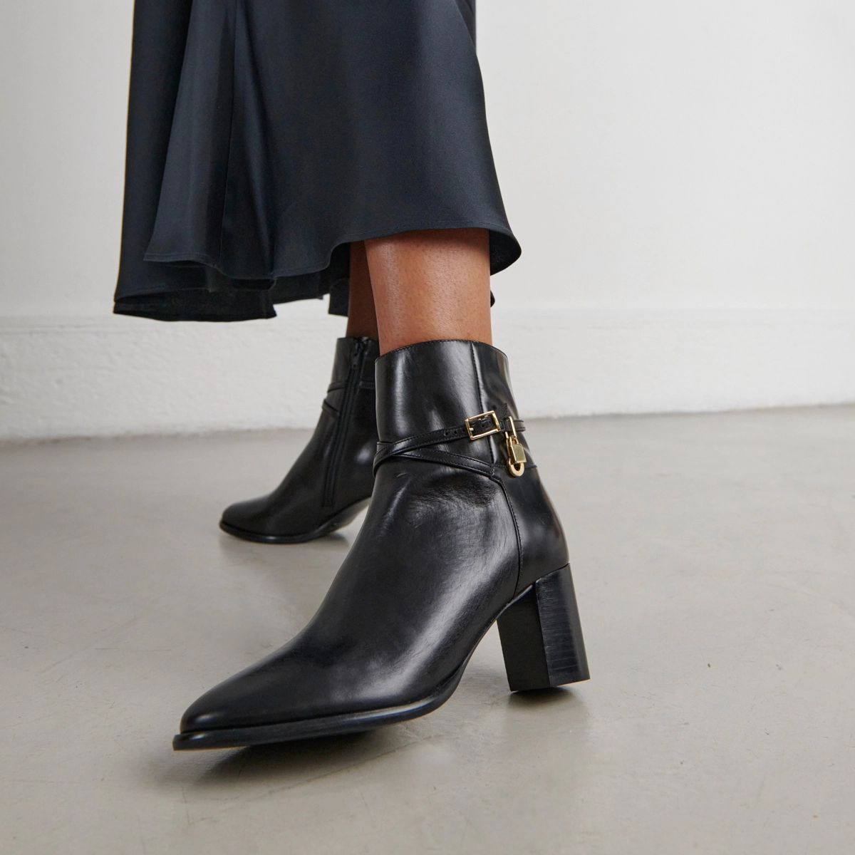 Ankle boots with high heels and gold charms in black leather | DRAME