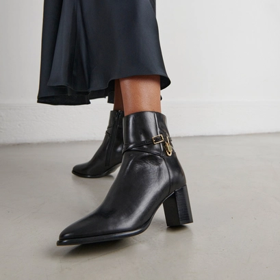 Ankle boots with high heels and gold charms in black leather | drame