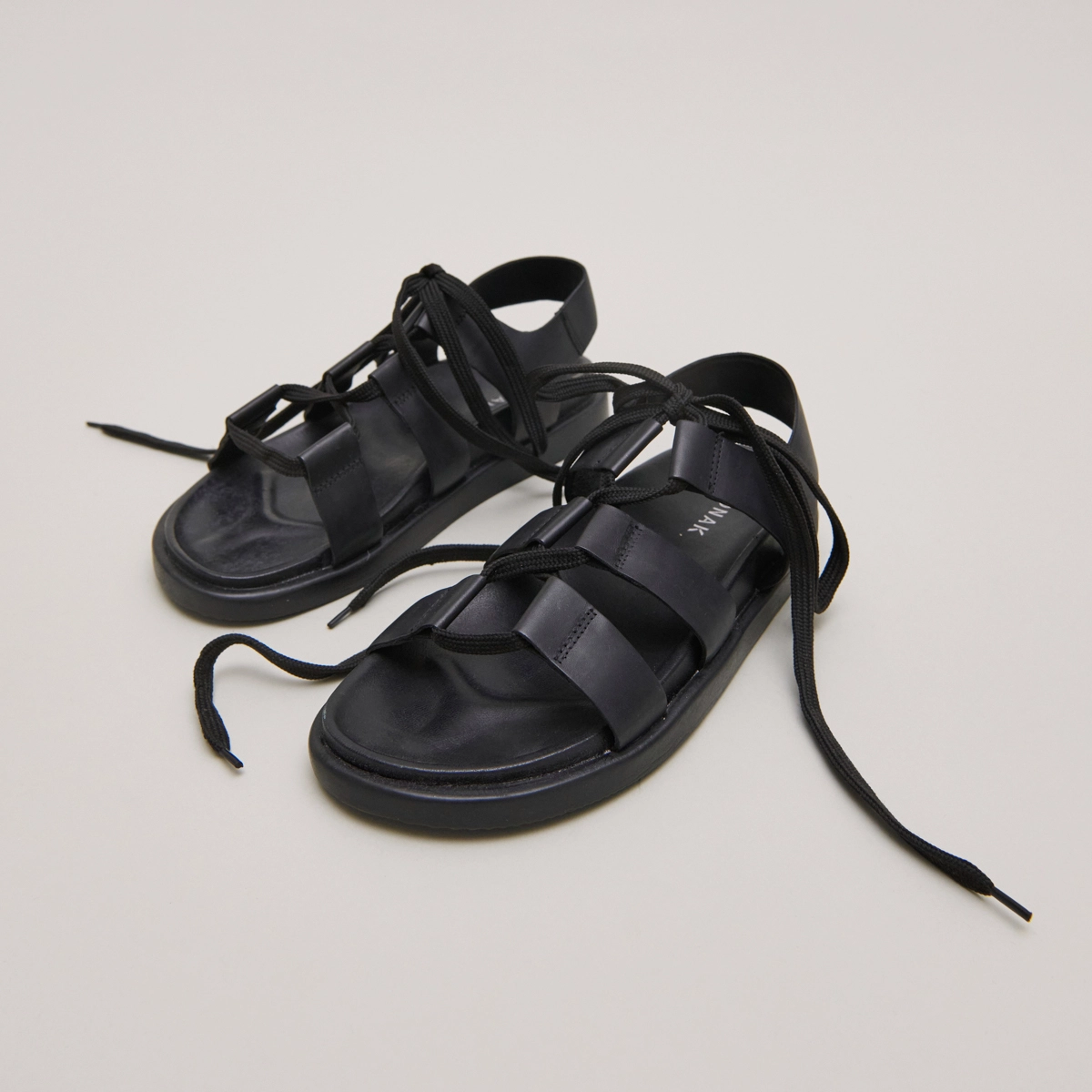 Sandals with multiple straps and laces in black leather | WELLINGTON