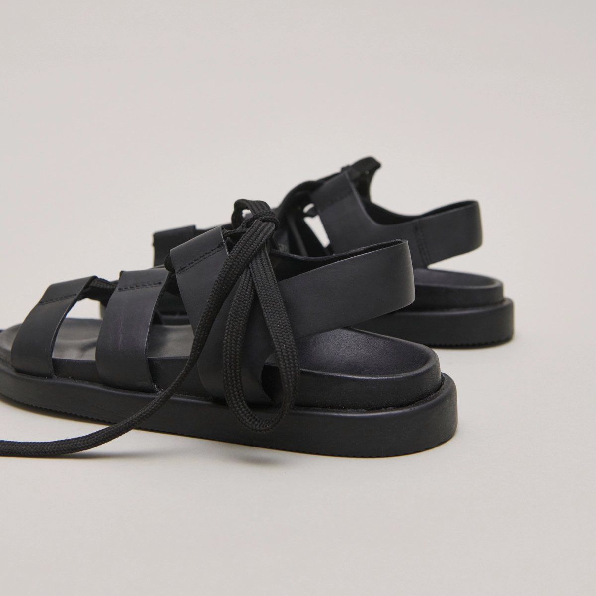Sandals with multiple straps and laces in black leather | WELLINGTON