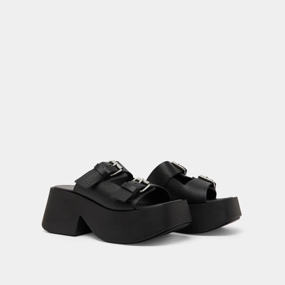 Mules with thick straps, buckles and open toes in black grained leather | ENOLA