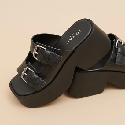 Mules with thick straps, buckles and open toes in black grained leather | ENOLA