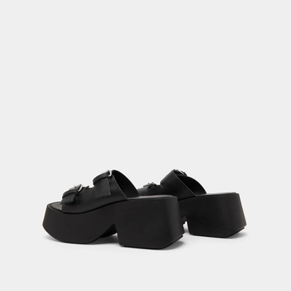 Mules with thick straps, buckles and open toes in black grained leather | ENOLA