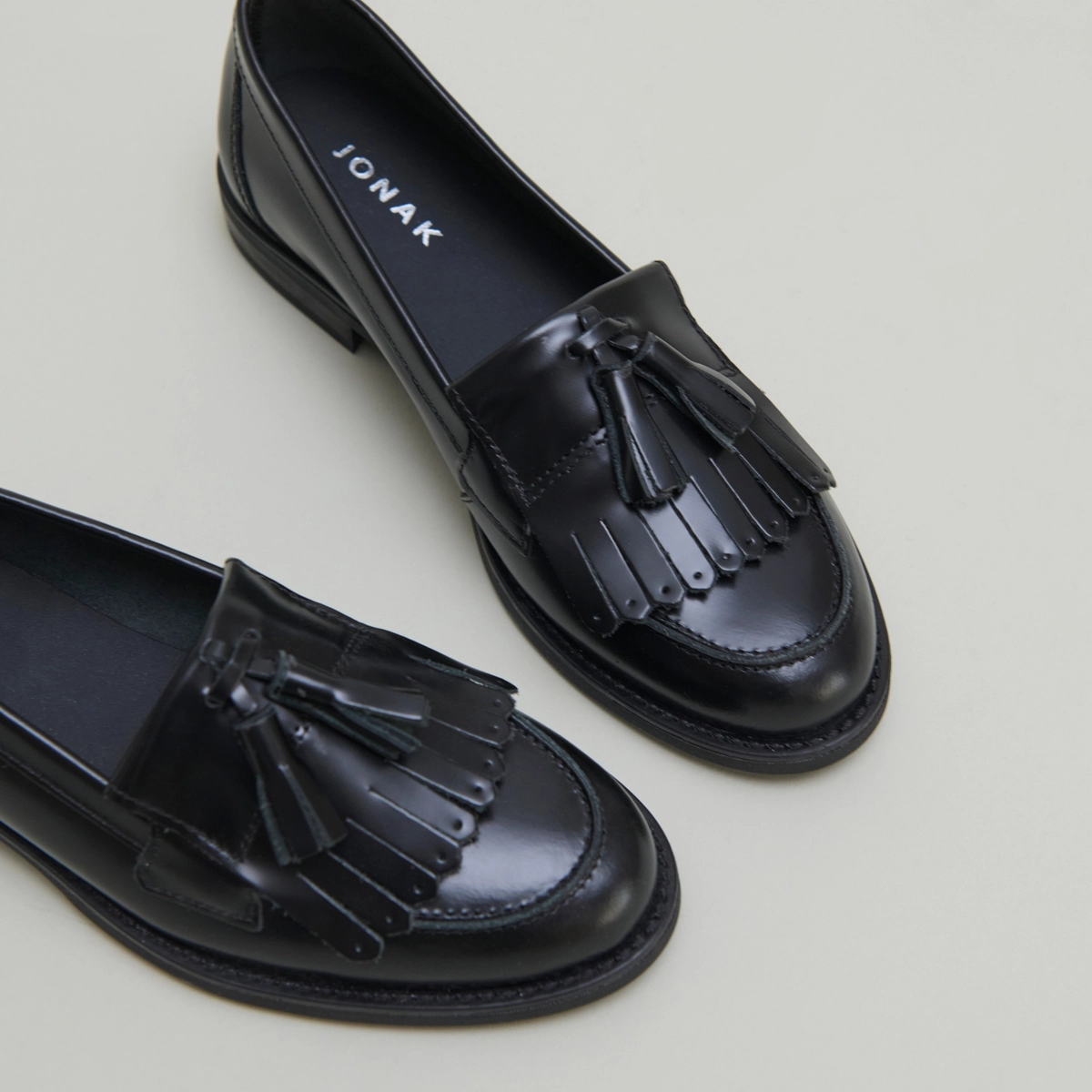 Tassel loafers in black glazed leather | NELLE